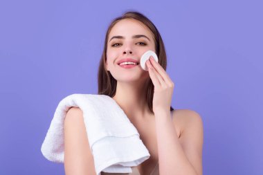 Beauty model cleansing her perfect skin by cotton pad sponge. Spa and wellness, skin care. Evening beauty routine. Beautiful woman cleaning her face with cotton pad. Skin treatment, cosmetology