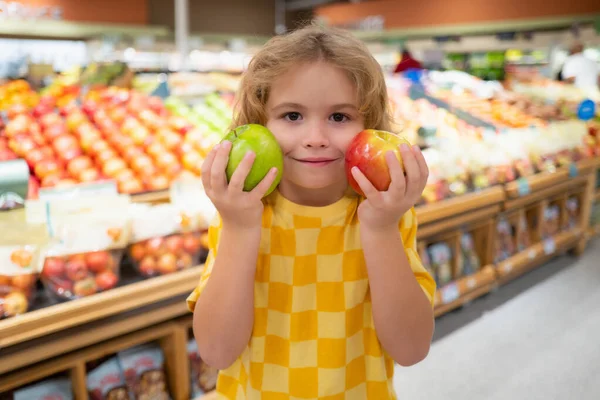 Child hold apple fruits at grocery store. Shopping in supermarket. Kids buying groceries in supermarket. Little boy buy fresh vegetable in grocery store. Child buy food