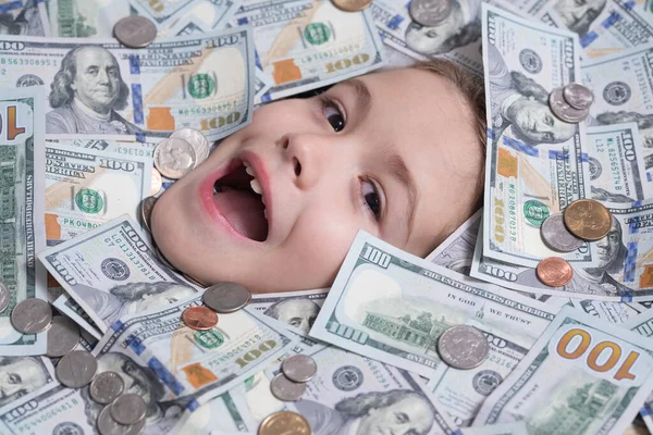 Funny child face in money dollars banknotes background. Money banknotes, cash dollars bills, 100 American dollars banknotes