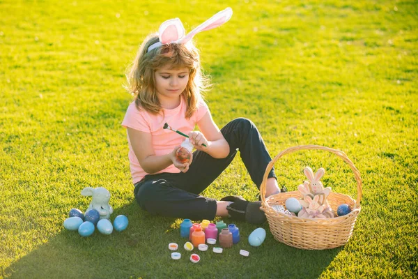 Пасхальный Мальчик Кроличьих Ушах Рисует Пасхальные Яйца Открытом Воздухе Симпатичный — стоковое фото