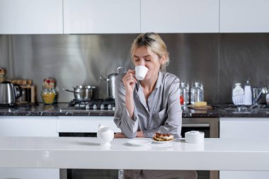 Beautiful woman drink coffee on kitchen at home