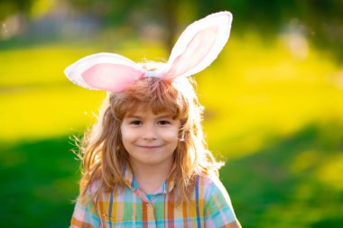 Easter kid in park. Child boy hunting easter eggs. Child boy with easter eggs and bunny ears in park