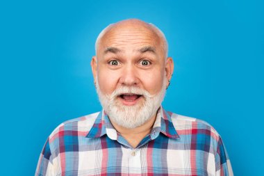 Middle aged surprised man on studio isolated background. Close up portrait of grey-haired mature senior man. Surprised old mature man face