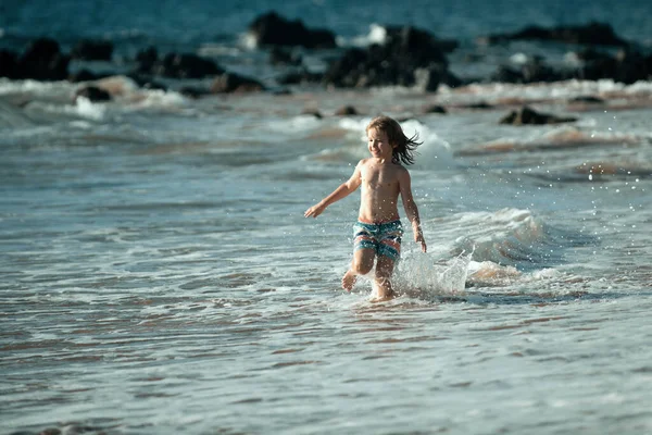 子供はビーチで走ってる 幸せな子供は夏休みに海で走ります 海や海での旅行と冒険 — ストック写真