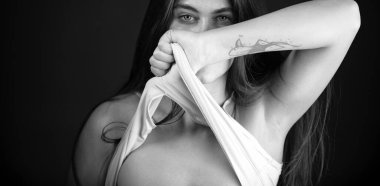 Woman in shadow show breast, tits. Sexy model with shadows on face looking seductive and sensual on dramatic black studio with light. Sensual seductive girl