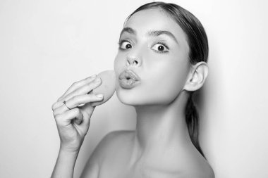 Kapatıcı ve kozmetik fosforlu kalem kullan. Kızın elinde kozmetik aplikatör var. Kadın yüzüne krem sürüyor. Cilt kremi kavramı. Kadın için yüz bakımı. Taze sağlıklı deri konsepti. Mükemmel ten rengi.