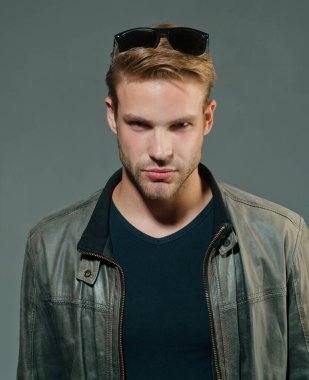 Yakışıklı adam - stüdyo portresi. Gri arka planda, fotokopi alanı olan neşeli genç adamın yakın plan portresi.