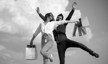Her zaman yanında bir alışveriş çantası var. Alışveriş çantalarında alışverişlerini taşıyan mutlu alışverişçiler. Sakallı adam ve kağıt torbalı seksi moda kadın. Aşık çift kağıt alışveriş çantaları tutarak.