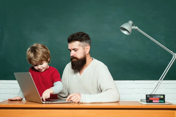 小学校の先生と教室の生徒 授業でノートパソコンを使う教師と生徒 黒板のコピースペース 父と息子小学校の子供と先生学校の教室で — ストック写真