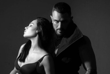 Kaslı adam. Karanlık arka planda aşık bir çift. Rahat ol. Güzel bir çiftin moda stüdyosu fotoğrafı. Aşık çift. Genç ve seksi bir çift. Onunla ilgili her şeyi seviyorum. Sevgi. Güzel genç aşıklar