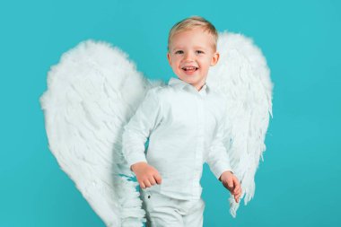 Güzel küçük melek izole edilmiş. Sevgililer Günü. Mavi arka planda duran beyaz elbiseli tatlı çocuk.