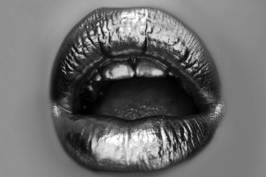 Lüks altın dudaklar makyaj. Altın rujlu altın dudaklar. Seksi kızın dudaklarında altın boya. Şehvetli bir kadın ağzı açık, izole bir geçmişi var. Altın sanat tasarımı