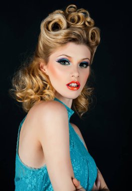 Güzel bir genç kadının şık stüdyo portresi. Kapatın bayan. Mavi elbiseli güzel sarışın kadın. Pin-up tarzı makyaj. Lüks makyaj. Mutlu kız. Eski saç stili olan güzel sarışın kadın.