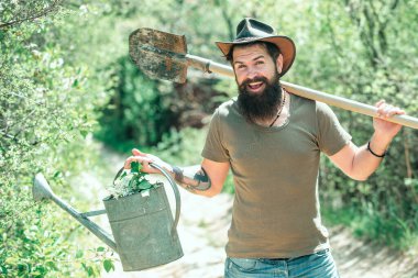 Aletleri olan bahçıvan. Kürek ve sulama tenekeli mutlu çiftçi. Kırsalda geçirdiğimiz zamanları seviyorum. Dünya günü. Yaz çiftçiliği