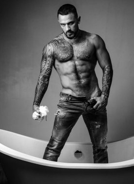 Güzel vücutlu, seksi, yakışıklı, üstsüz erkek model. Gövdesi kaslı seksi bir adam. Altı paket ve karın kaslı vücut koyu arkaplanda poz verir.