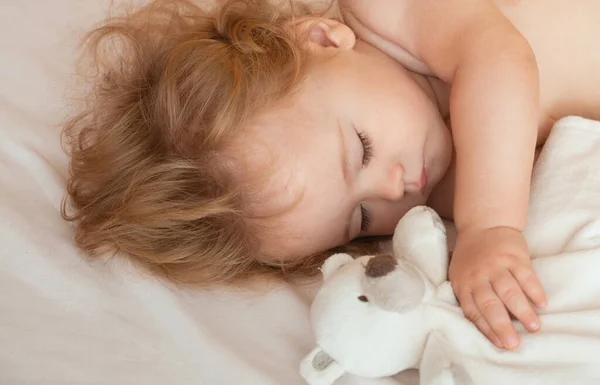 美しい赤ちゃんはおもちゃで家のベッドで寝て 子供はベッドで寝て — ストック写真