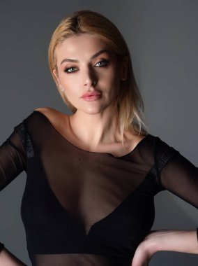 Güzel bir genç kadının stüdyo portresi. Temiz ciltli güzel bir manken kız. Güzellik, sağlık. Gri stüdyo arka planında bir model. Saç stili olan çekici bir kadın portresi.