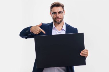 Boş afişi olan yakışıklı, orta yaşlı bir adam. Metnin ya da tasarımın için kopyalama alanı gösteriliyor. Stüdyo arka planında boş reklam panosu gösteren bir adam. Boş pano, reklam tabelası.