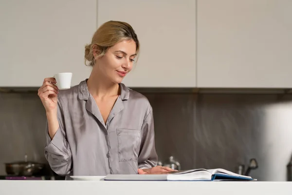 ブロンドの美しいセクシーな女の子は自宅でキッチンで朝のコーヒー 読書本や雑誌を飲む 可愛い女の朝 — ストック写真
