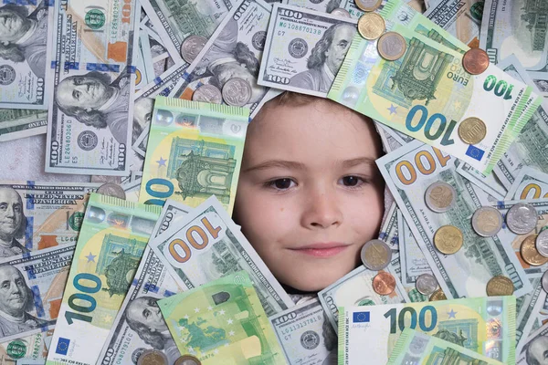 Euro and dollar concept. Funny child with fun face with money. Kid peeking out of dollar bills with astonished shocked eyes. Money background