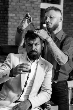 Barbershop ve Berber salonu hakkında fikirler. Modern Berber Dükkanı'ndaki acımasız adam. Kuaför saç stilini sakallı bir adam yapar. Berber - Tıraş ve Süsler. Sakal bakımı