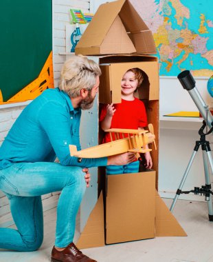Parenting childhood. Childhood Dreams of space. Childin astronauts costumes with toy rocket playing and dreaming of becoming a spacemen