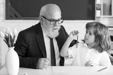 Öğretmenlik konsepti. Öğrenmeme yardım et. Eski öğretmen ve okul çocuğu sınıfta. Öğretmenlik, eğitim, öğretmenlik. Öğrenci çocuk dersi.