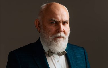 Ciddi kıdemli adam. Sakallı, orta yaşlı, ciddi bir yüz ifadesi olan, yakın plan bir kafa ve omuz portresi olan adam.
