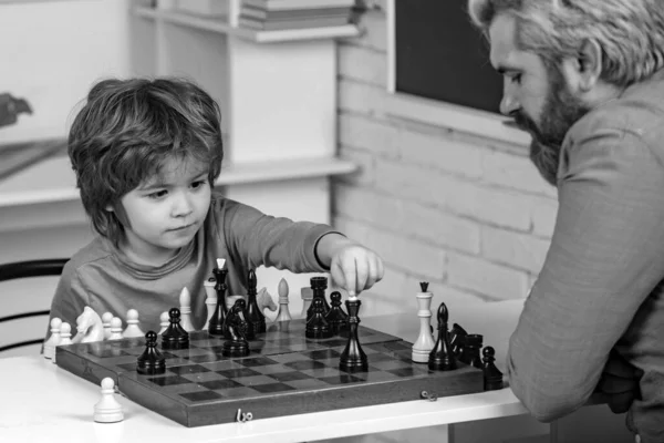 Father teaching son. Teacher and child. Parenthood. Back to school and Education concept. Boy think or plan about chess game - style for education concept