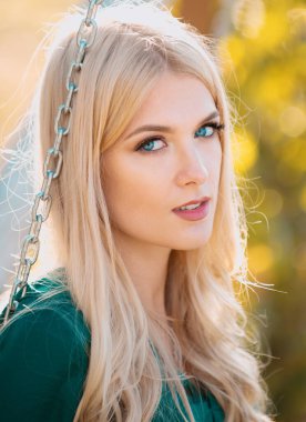 Genç ve şık bir kadının yüzünü kapatın. Güzel, düşünceli, açık hava portresi kızı. Genç sarışın kadın güneşli yaz gününde