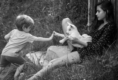 Vejetaryen konsepti. Hayvanlarla arkadaşlık. Çocukların adaptasyonu. Kırsal hayvanlar. Keçi sütü. Kuzu kız. Keçili kadın ve çocuk