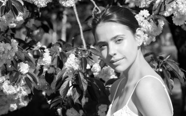 Kirazlı sakura çiçekli kız. Açık hava portresi. Güzel, şehvetli moda kızları. Çiçekli bir ağacın yanında pembe çiçeklerle poz veriyorlar.