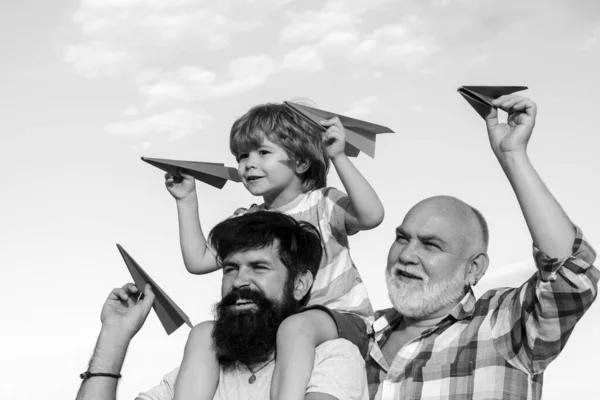 孩子们在阳光灿烂的日子玩着简单的纸飞机 父亲开车送儿子回公园 一代的概念 孩子们很快乐三代男人 — 图库照片