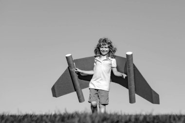 Gökyüzü arka planında oyuncak jetpack 'i olan çocuk pilot. Mutlu çocuk dışarıda oynuyor. Mutlu bir çocukluk. Çocukların hayal gücü.