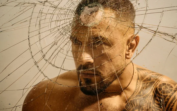 stock image Overcoming the obstacle. Determined man knocking down a glass wall with a head, obstacle concept. Strong latino man removing obstacle on his way. Facing obstacle to goal achievement.