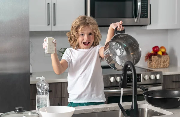 台所のシンクの近くに面白い興奮した子供の洗濯皿 — ストック写真