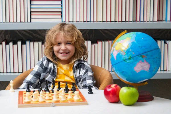 Chess school for children. Clever concentrated and thinking child playing chess. Child boy developing chess strategy, playing board game