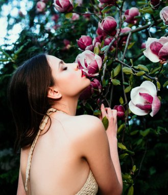 Bahar moda konsepti. Bahar Magnolia çiçek arka planında moda bahar kızı. Bahar çiçeğinin arkasındaki kadın.