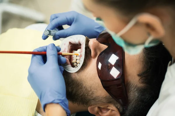 Słodki Młody Człowiek Uśmiechnięty Aparat Fotograficzny Dentystka Sprawdzająca Zęby Pacjenta — Zdjęcie stockowe
