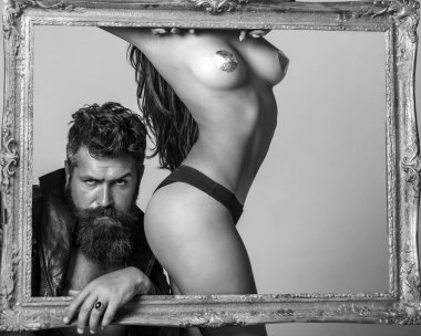 Seksi iç çamaşırlı kadın. Ellerinde klasik ahşap çerçeve var. Fotoğrafı kapat. Kaslı baskın adam. Samimi ilişki ve cinsel ilişki. Genç ve seksi bir çift. Erotik oyunlar arzu