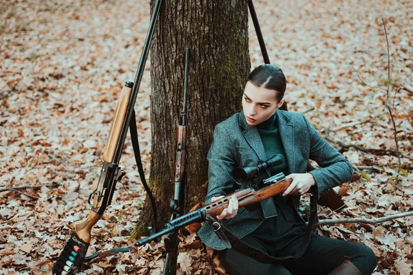 girl with rifle. chase hunting. Gun shop. woman with weapon. Target shot. successful hunt. hunting sport. female hunter in forest. military fashion. achievements of goals. charging a hunting rifle.