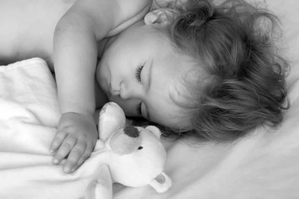 美しい赤ちゃんはおもちゃで家のベッドで寝て 子供はベッドで寝て — ストック写真