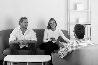 Sosyal Hizmetler psikoloğu genç bir çiftle konuşuyor. Depresyon terapisi, aile terapisi.