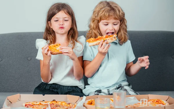 Children eating pizza. Little girl and boy eat pizza