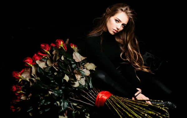 Valentines day flower present. Sexy girl with big rose bouquet. Rich woman