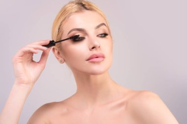 Kirpik şekillendiren kadın. Güzel kirpikli kadın gözü. Uzun kirpiklerle şekillendirilmiş. Kirpikleri boyayın. İzole edilmiş stüdyo geçmişinde kırbaçlanan kız