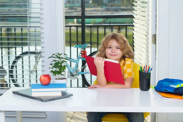 School kid reading book. Nerd school kid doing homework at home. Clever child from elementary school with book. Smart genius intelligence kid ready to learn. Hard study