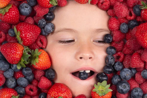 Vitamins from berrie. Berries mix blueberry, raspberry, strawberry, blackberry. Child face with berry frame, close up