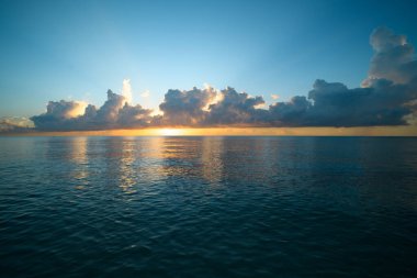 Sunset sea landscape. Colorful beach sunrise with calm waves. Sunrise over the sea and beautiful clouds. Nature sea sky. Sunrise with clouds of different colors against the blue sky and sea