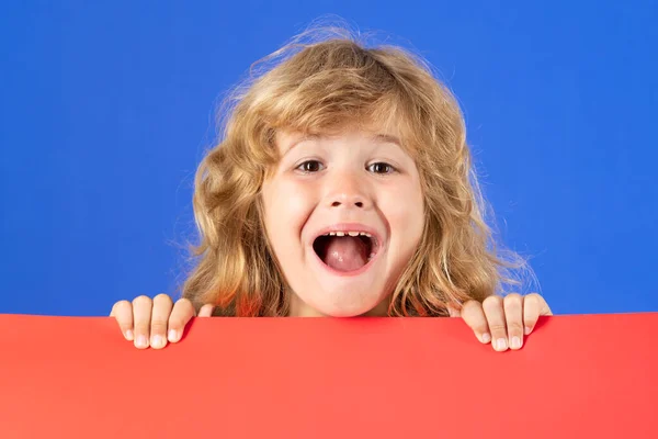 スタジオの背景に赤い空のバナーを持つ面白い笑顔の子供の興奮した肖像画 広告看板 プラカード コピースペース あなたのテキストのポスター — ストック写真